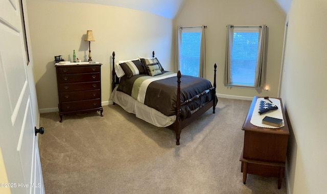 bedroom with light colored carpet and lofted ceiling