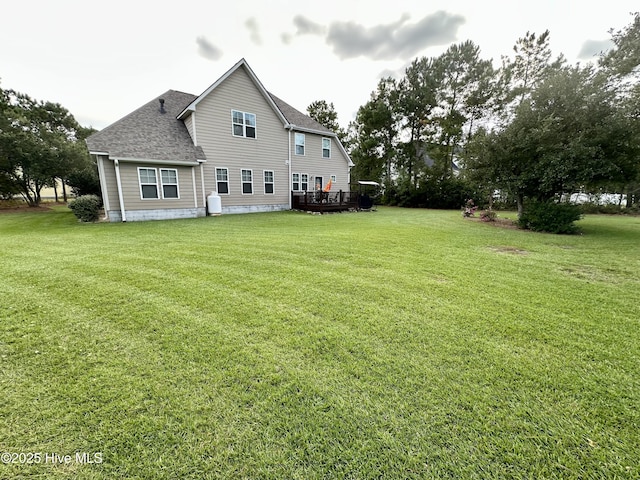 rear view of house with a wooden deck and a yard