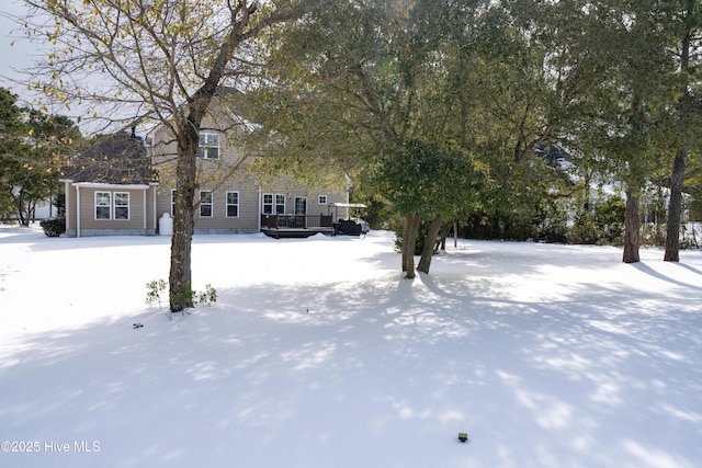 yard covered in snow featuring a deck