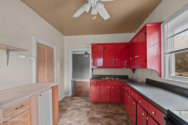 kitchen featuring ceiling fan, sink, and range