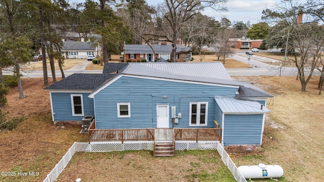 back of property featuring a deck and a lawn