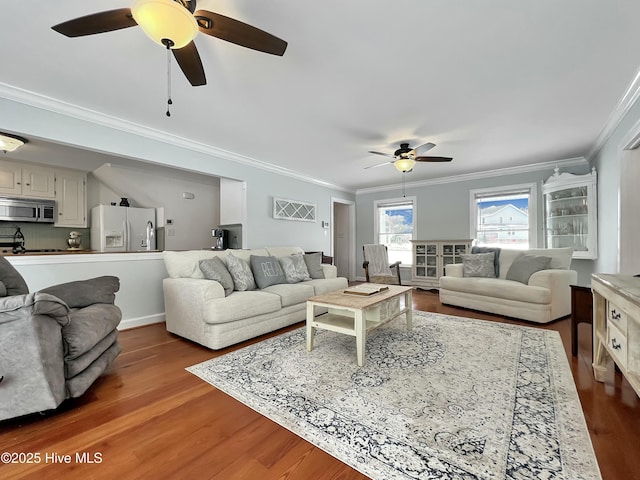 living room featuring ornamental molding, wood-type flooring, and ceiling fan