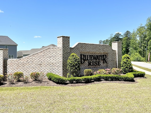 community sign featuring a yard