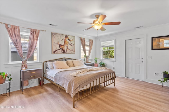 bedroom featuring crown molding, light hardwood / wood-style floors, and ceiling fan