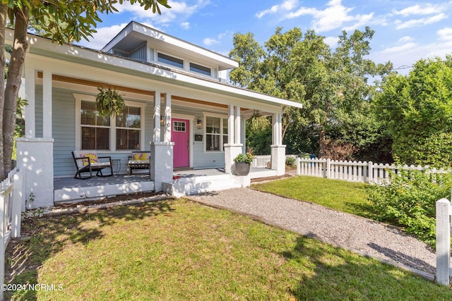 view of front of home featuring covered porch and a front lawn