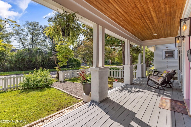 wooden deck with a porch and a lawn