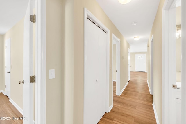 hallway with light hardwood / wood-style floors