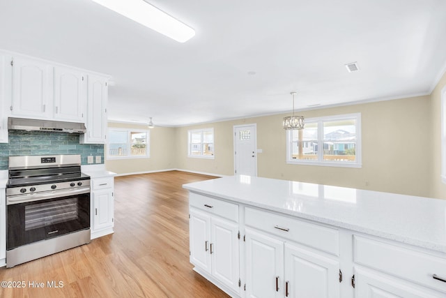 kitchen featuring pendant lighting, white cabinetry, backsplash, light hardwood / wood-style floors, and stainless steel electric stove