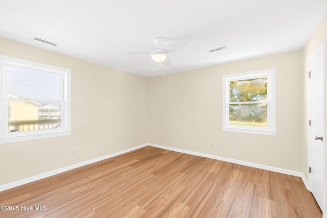 spare room featuring light hardwood / wood-style flooring, a wealth of natural light, and ceiling fan