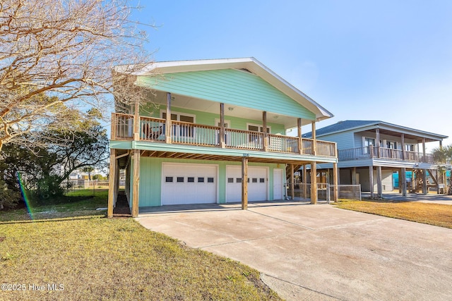 view of front of property featuring a garage, a front yard, and a balcony