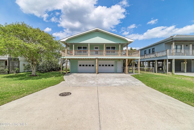beach home with an attached garage, concrete driveway, and a front lawn