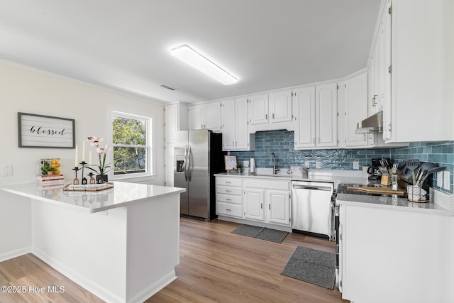 kitchen featuring white cabinets, under cabinet range hood, light wood-style floors, stainless steel appliances, and a sink