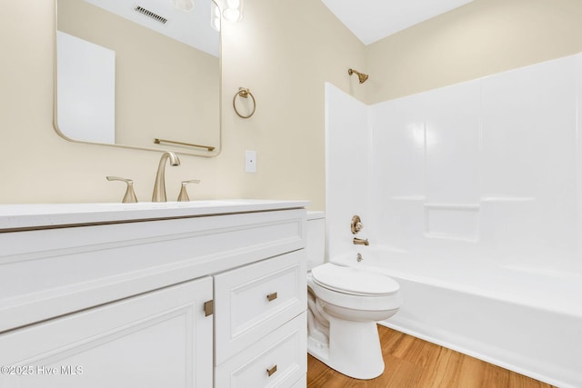 full bathroom with vanity, toilet, hardwood / wood-style floors, and  shower combination