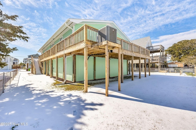 snow covered rear of property featuring a wooden deck