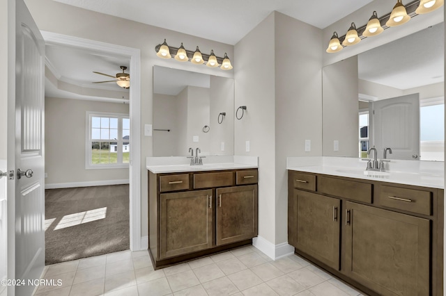 bathroom with ceiling fan, tile patterned floors, vanity, and a tray ceiling