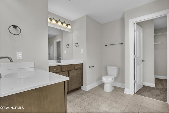 bathroom featuring toilet, vanity, and tile patterned flooring