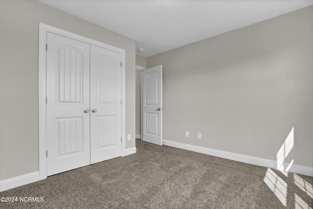 unfurnished bedroom featuring a closet and carpet flooring