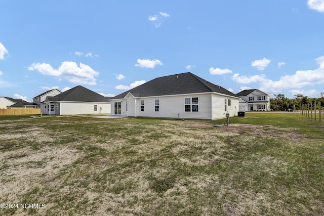 back of property with a patio area and a yard