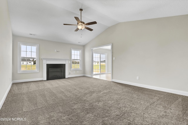 unfurnished living room with ceiling fan, a wealth of natural light, carpet floors, and lofted ceiling