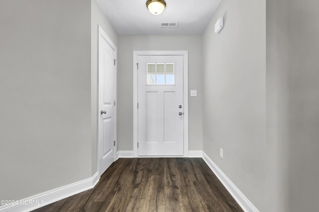 foyer entrance featuring dark hardwood / wood-style flooring and a textured ceiling