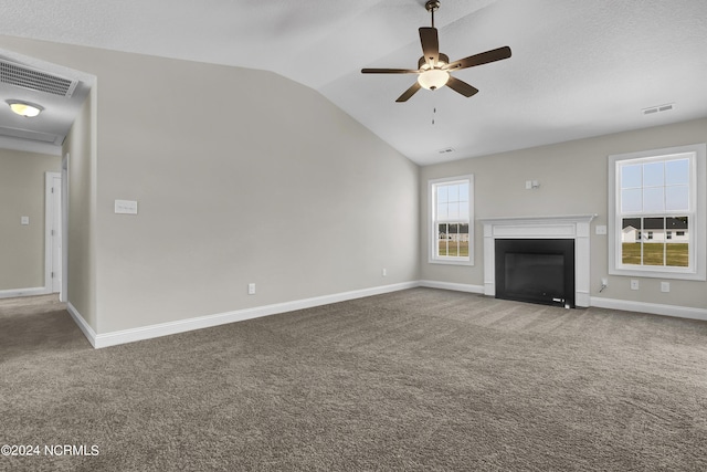 unfurnished living room featuring lofted ceiling, ceiling fan, a textured ceiling, and carpet