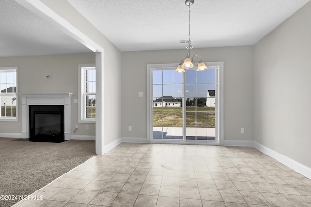 unfurnished dining area featuring a textured ceiling, light carpet, and a chandelier