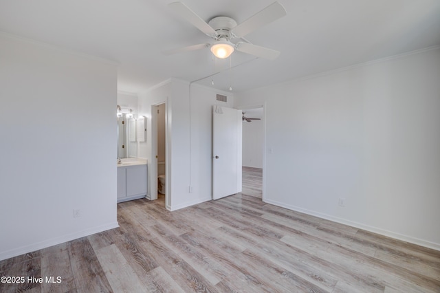 unfurnished bedroom with light wood finished floors, visible vents, ornamental molding, ensuite bath, and baseboards