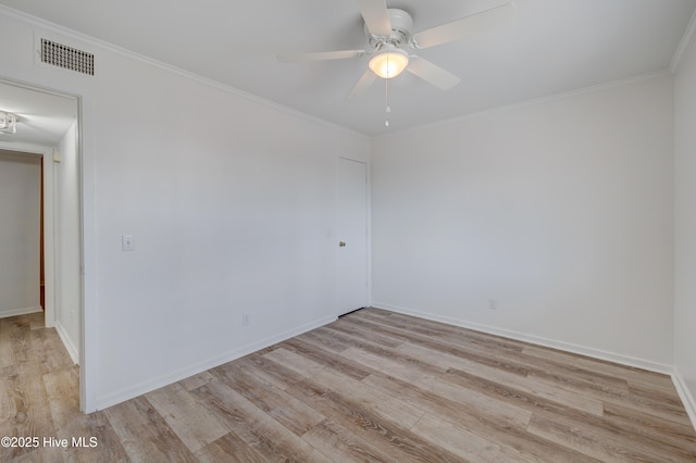 spare room featuring ceiling fan, visible vents, baseboards, light wood-style floors, and ornamental molding