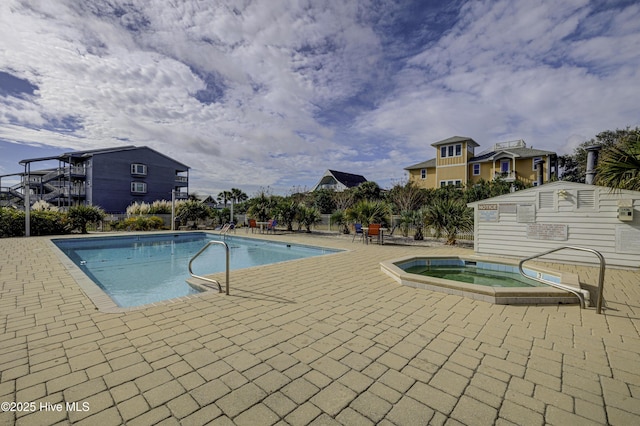 outdoor pool featuring a hot tub and a patio