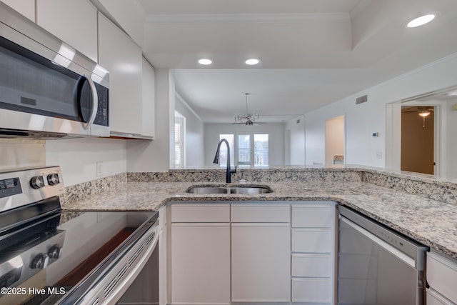 kitchen featuring white cabinetry, appliances with stainless steel finishes, a sink, and ornamental molding