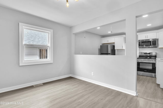 kitchen with white cabinetry, light hardwood / wood-style flooring, and stainless steel appliances