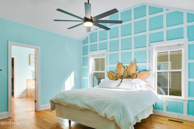 bedroom with lofted ceiling, hardwood / wood-style floors, ensuite bath, and ceiling fan