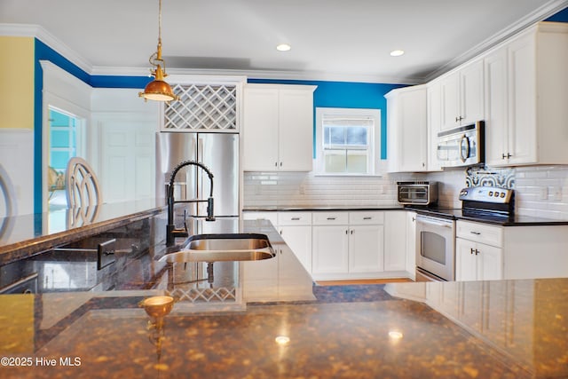 kitchen featuring decorative light fixtures, white cabinets, and stainless steel appliances