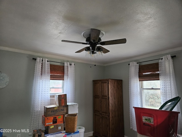 interior space featuring ceiling fan, multiple windows, ornamental molding, and a textured ceiling