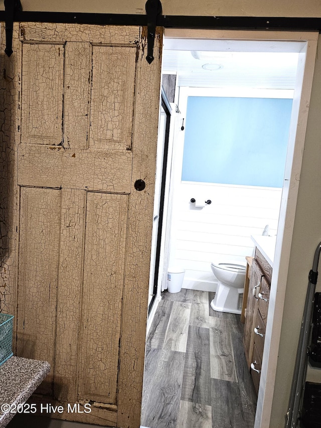 bathroom with hardwood / wood-style floors, toilet, and vanity