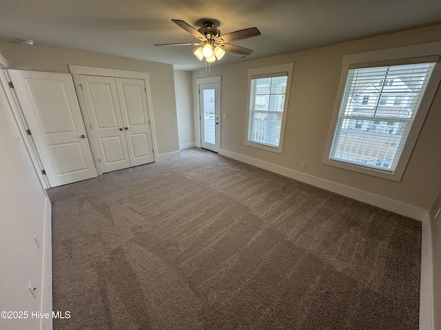 unfurnished room with ceiling fan and carpet