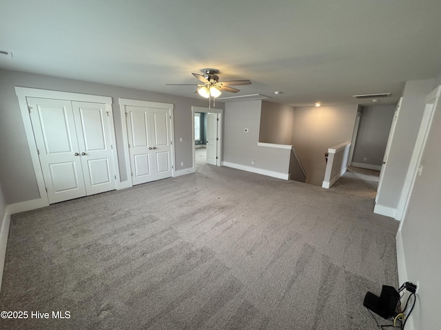 unfurnished living room featuring ceiling fan and carpet flooring