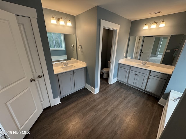 bathroom featuring wood-type flooring, toilet, and vanity