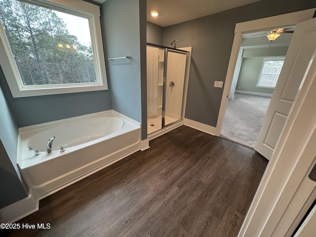 bathroom featuring plus walk in shower and hardwood / wood-style floors