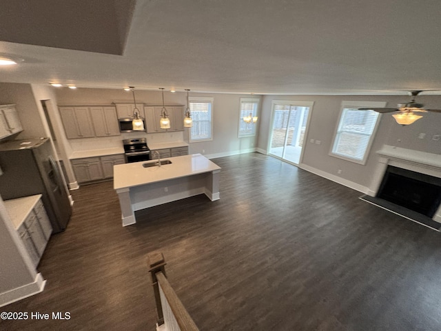 kitchen with dark wood-type flooring, sink, gray cabinetry, decorative light fixtures, and appliances with stainless steel finishes