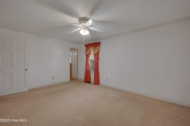 carpeted spare room featuring ceiling fan and ornamental molding