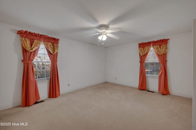 carpeted spare room with ceiling fan