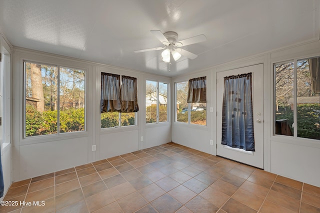 unfurnished sunroom featuring ceiling fan