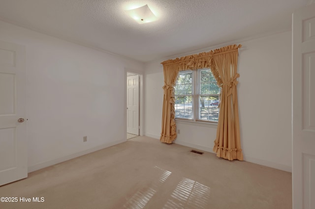 unfurnished room with a textured ceiling and carpet flooring