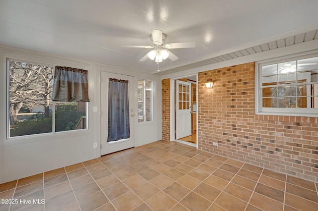 spare room with brick wall and ceiling fan