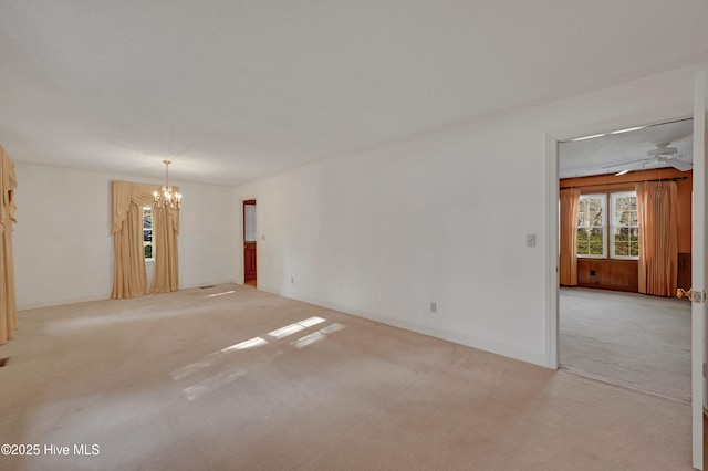 carpeted empty room featuring a chandelier