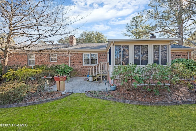 rear view of house with a yard and a sunroom