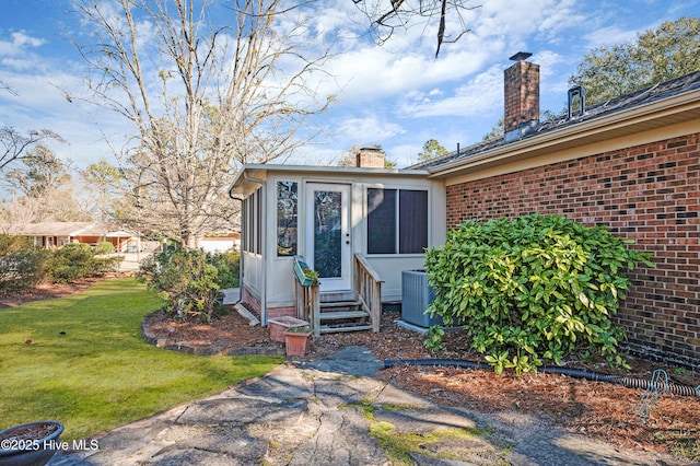 doorway to property with cooling unit and a yard