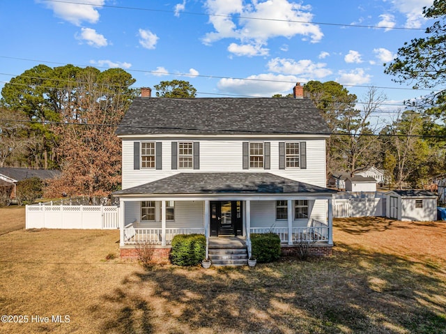 front facade with a porch, a front lawn, and a storage shed