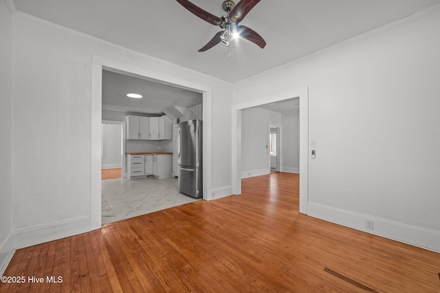 unfurnished living room featuring crown molding, light hardwood / wood-style floors, and ceiling fan